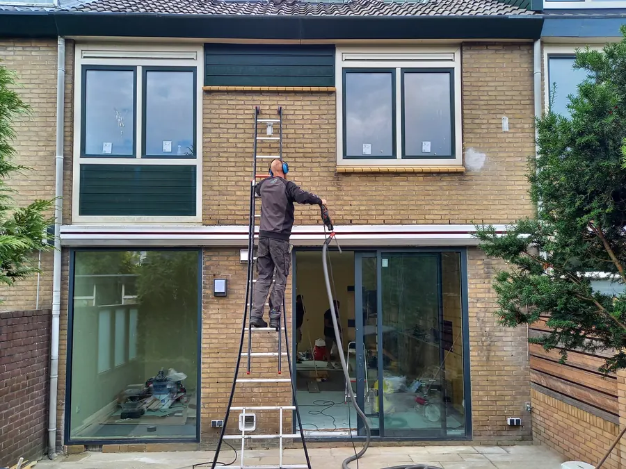 Installateur brengt spouwmuurisolatie aan bij een woning